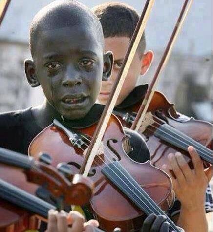 This child played a violin at his teacher's funeral. That teacher helped him escape poverty & violen