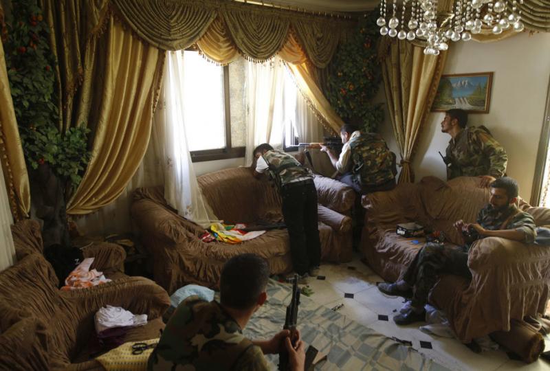 A Free Syrian Army fighter fires his sniper rifle from a house in Aleppo August 14, 2012