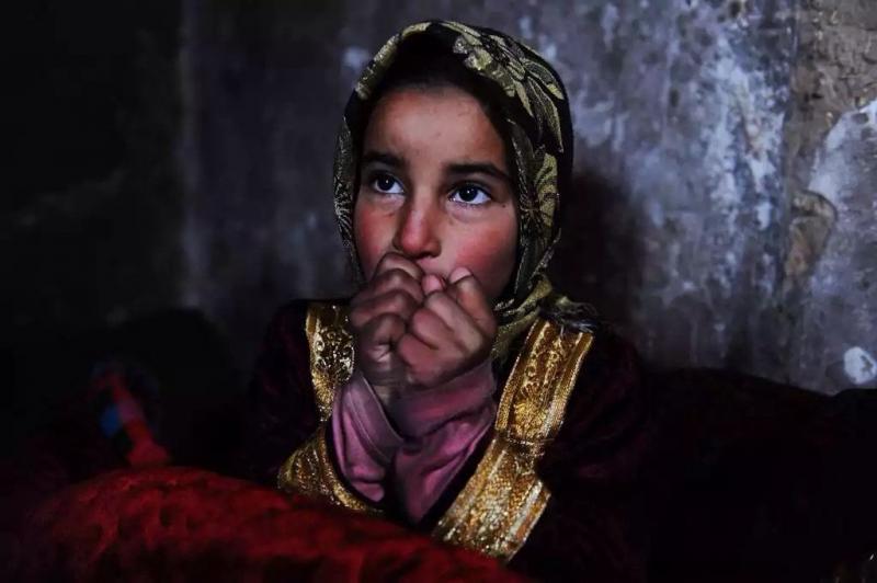 أفضل صور العالم لعام ٢٠١٤ حسب WSJ - طفلة افغانية تحاول تدفئة نفسها خلال موسم البرد في هيرات 