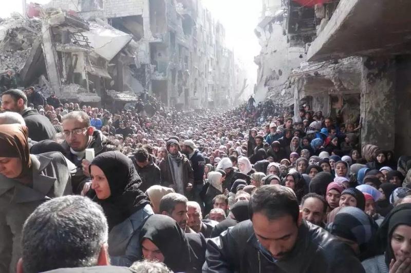 أفضل صور العالم لعام ٢٠١٤ حسب WSJ - آلاف اللاجئين في مخيم اليرموك السوري بانتظار توزيع الطعام عليهم 