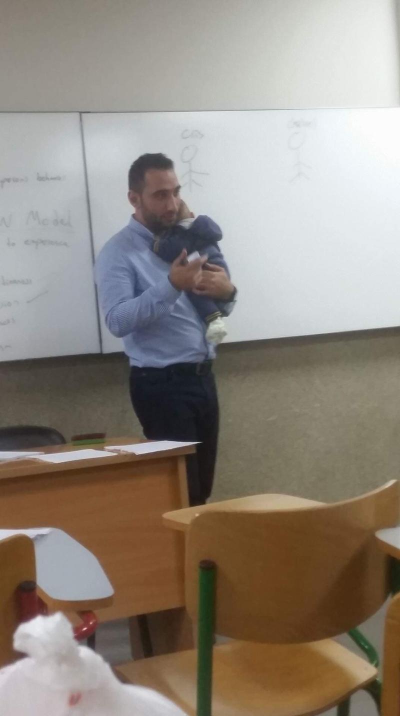الدكتور #حسن_شمص المدرس في جامعة #بيروت العربية يحمل طفلة احدى تلميذاته لتتمكن من التركيز في المحاضرة #لبنان - صورة ١