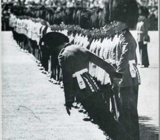 A British guardsman falls to the ground during Trooping the Colour ceremony, from heat exhaustion. London. 1957.