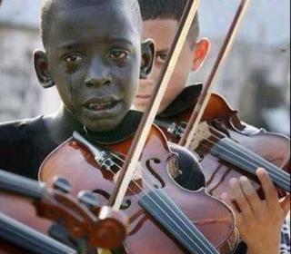 This child played a violin at his teacher's funeral. That teacher helped him escape poverty & violen